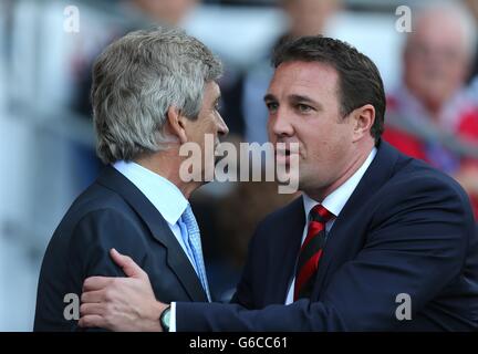 Cardiff City Manager Malky Mackay und Manchester City Manager Manuel Pellegrini (links) grüßen sich vor dem Anpfiff Stockfoto