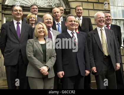 Das neue schottische Kabinett mit (von links nach rechts hinten Reihe) Frank McAveety Tourismusminister, Peter Peacock Bildung, Nicol Stephen Transport, (zweite Reihe) Margeret Curran Gemeinschaften, Malcolm Chisholm Gesundheit, Andy Kerr Finanzen, Colin Boyd Lord Advocate, Ross Finnie Rural, Patricia Ferguson Parlamentarische Bürgschaft, (erste Reihe) Cathy Jamieson Justiz, Erster Minister Jack McConnell und Jimm Wallace Enterprise Minister vor Bute Haus in Edinburgh. Stockfoto