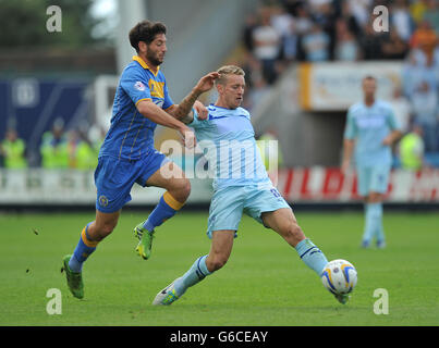 Carl Baker von Coventry City schlägt Joe Jacobson von Shrewsbury Town während des Sky Bet Football League One-Spiels auf der Greenhous Meadow, Shrewsbury, zum Ball. Stockfoto