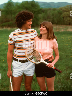 1970S 1980S PAAR TRAGEN TENNIS SHORTS HOLDING SCHLÄGER Stockfoto