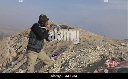 Islamischer Staat Kämpfer feuert ein Ak-47 bei kämpfen in den Bergen Makhoul 30. Mai 2016 in der Nähe von Baiji, Irak. Das Standbild wird aus einem Propaganda video veröffentlicht von der islamischen Staates im Irak und der Levante erfasst. Stockfoto