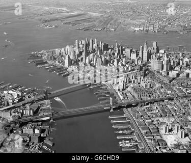 1950ER JAHREN ANTENNE VON DOWNTOWN MANHATTAN EAST UND HUDSON FLÜSSE TREFFEN SICH IM HAFEN BROOKLYN UND MANHATTAN BRIDGE Stockfoto