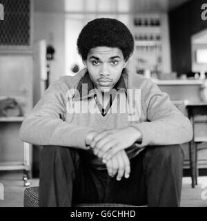 1970ER JAHRE PORTRAIT AFROAMERIKANISCHE JÜNGLING BLICK AUF KAMERA SCHWEREN AUSDRUCK TRAGEN PULLOVER Stockfoto