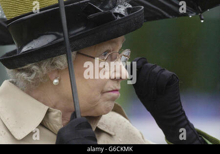 Die britische Königin Elizabeth II. Wirft einen Blick auf ein Pferd, während sie den Wettkämpfern des Services Team Jumping auf der Royal Windsor Horse Show Rosetten präsentiert. Stockfoto