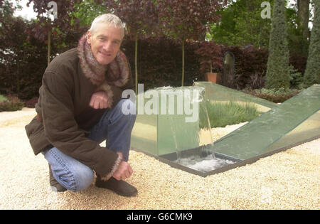 James Dyson hockt neben einem Teil seines 'The Wrong Garden', der 2003 auf der Chelsea Flower Show im Zentrum von London ausgestellt wurde und von ihm mit Hilfe von Jim Honey entworfen wurde. Im Mittelpunkt des Gartens steht der Wasserbrunnen von James, wo das Wasser nach oben zu fließen scheint. * die Chelsea Flower Show findet auf dem Gelände des Royal Hospital, Chelsea, statt und ist für Mitglieder der Royal Horticultural Society (RHS) am Dienstag und für die Öffentlichkeit am Mittwochnachmittag geöffnet. Stockfoto