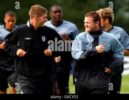 Die englischen Spieler Wayne Rooney (rechts) und Steven Gerrard (links) teilen sich einen Witz während eines Mannschaftstrainings in Champney's Springs, Leicestershire, um sich auf Englands internationales Freundschaftsspiel gegen Serbien-Montenegro im Walkers Stadium von Leicester City am Dienstag vorzubereiten. Stockfoto