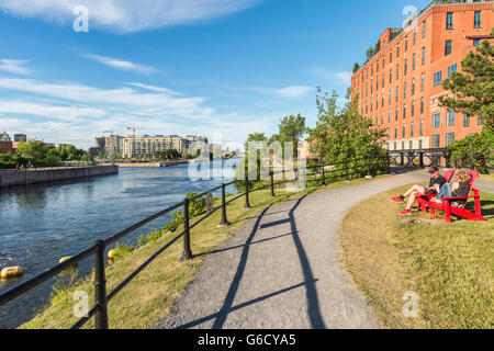 Lachine Canal Radweg in Montreal mit zwei Personen sitzen auf Stühlen im Chat Stockfoto