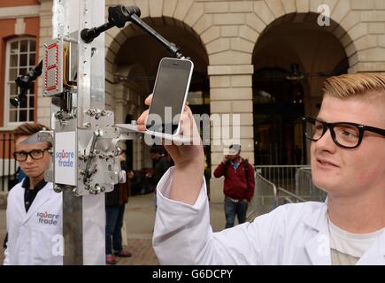 Ein Arbeiter für Square Trade, ein Handy-Garantie-Unternehmen, fügt ein neues Apple iPhone in den "Phone Terminator", um die beiden neuen Angebote von Apple außerhalb des Apple Store in Covent Garden in London zu testen. Nach zweimaliger Fallenlassen blieben beide neuen Modelle zerkratzt, leicht beschädigt, aber immer noch funktionsfähig. Stockfoto