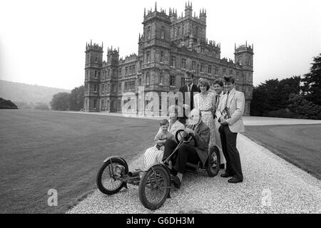 Der siebte Earl of Carnarvon sitzt in der 1922 Familie Red Bug Buckboard - vermutlich der einzige im Land - umgeben von Mitgliedern seiner Familie in Highclere Castle, in der Nähe von Newbury, Bereit, Besucher willkommen zu heißen, wenn ihr Haus am 3. Juli zum ersten Mal für die Öffentlichkeit geöffnet wird. Stehend, von links: Lord Porchester, 31, ältester Sohn und Erbe; Tochter Lady Carolyn Warren, 26, und ihr Ehemann John, und Sohn Harry Herbert. Die Gräfin von Carnarvon hält ihren Enkel Jake, Sohn von Lady Carolyn. Stockfoto