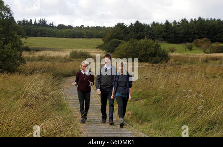 Nick Clegg, Vorsitzender der Liberaldemokraten, mit Dr. Maggie Keegan (links), Head of Policy des Scottish Wildlife Trust, und Laura Cunningham (rechts), Projektleiterin von Cathkin Marsh bei Glasgow, während der Herbstkonferenz der Liberaldemokraten in Glasgow, Schottland, bei einem Besuch bei Cathkin Marsh in der Nähe von Glasgow. Stockfoto