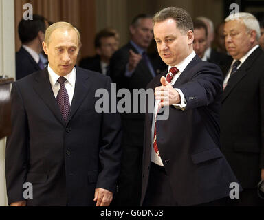 Der russische Präsident Wladimir Putin wird von dem schottischen Ersten Minister Jack McConnell (rechts) in der Signet Library in Edinburgh auf seinen Sitz gebracht. Putin befindet sich derzeit auf einem offiziellen Staatsbesuch in Großbritannien. Stockfoto