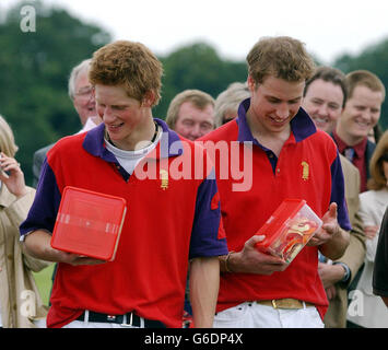 Prinz William (rechts) und Prinz Harry inspizieren ihre Preise - Tuck Shop, Scary Snakes - nach ihrem Spiel gegen Altu im Cirencester Park. Stockfoto