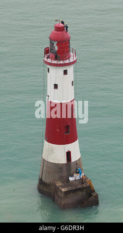 Ingenieure balancieren auf der Spitze des Beachy Head Lighthouse in der Nähe von Eastbourne, Sussex, während der Prozess der Neulackierung der Struktur nach einer erfolgreichen Spendenaktion zur Rettung der Streifen beginnt. Stockfoto