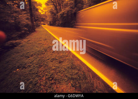 Abstrakt - eine langsame Belichtungszeit Weitwinkel-Bild eines Transporters auf einem ländlichen Autobahn unterwegs. Ein Gelbfilter ist über die Linse verwendet. Stockfoto