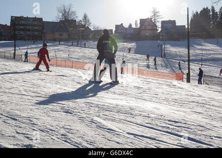 Skifahren und Rutschen, Winterzeit im Tatra-Gebirge. Stockfoto