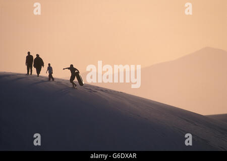 USA, New Mexico, White Sands National Monument, Silhouette der Familie oben auf Gips Sanddüne in der Chihuahua-Wüste bei Sonnenuntergang Stockfoto