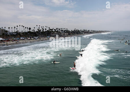 Surfer fangen "Partei-Welle" nach der Teilnahme an einem Paddel aus lokalen Surf-Legende Skydog Oceanside Beach in Oceanside, Kalifornien, am 3. August 2014 genannt zu Ehren. Stockfoto