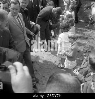 PRÄSIDENT JOHN F. KENNEDY von Amerika, selbst ein Familienmensch, stockt, um die Hand zu nehmen und mit einem kleinen Mädchen zu sprechen, einem der Kinder, die er begrüßte, bevor er seinen Hubschrauber bestieg, um nach Dublin zurückzukehren, nachdem er das Haus seines Vorfahren in Dunganstown, New Ross, Co. Wexford, besucht hatte, Während seines dreitägigen Aufenthalts in Irland. Mr. Kennedys Urgroßvater lebte in Dunganstown, bevor er 1850 nach Amerika auswanderte. Bei seinem Besuch traf Mr. Kennedy eine Reihe seiner irischen Verwandten in Dunganstown. Stockfoto