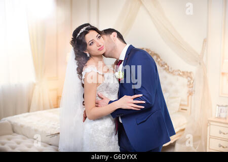Der Bräutigam sanft umarmt und küsst die Braut