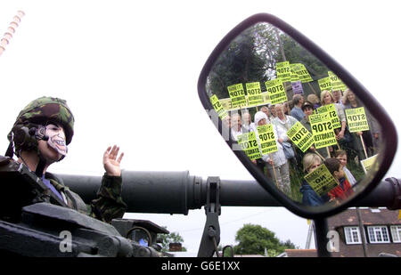 Der Protestant Ed Jones, der eine Tony Blair Maske trägt, sitzt auf einem Tank vor dem mittelalterlichen Three Horseshoes Pub in Mole Hill Green, Essex, nahe dem Flughafen Stansted, um zu demonstrieren, wie viele historische Gebäude zerstört werden, wenn die Erweiterung des Flughafens vorangeht. *...die Stop Stansted Expansion Kampagne, die symbolisch die Kneipe 'sprengte', sagen, dass die drei Horseshoes niedergeschlagen werden, wenn Pläne Schieß los.. Stockfoto