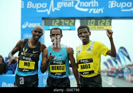 Großbritannien Mo Farah (links), Äthiopien Kenenisa Bekele (Mitte) und Äthiopien Haile Gebrselassie nach dem Great North Run 2013 zwischen Newcastle und South Shields. Stockfoto