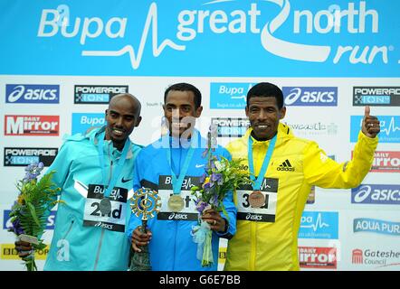 Kenenisa Bekele (Mitte) aus Äthiopien feiert nach dem Sieg beim Großen 2013 North Run zwischen Newcastle und South Shields vor Great Der Brite Mo Farah (links), der Zweiter wurde, und der Äthiopier Haile Gebrselassie, der auf dem dritten Platz war Stockfoto