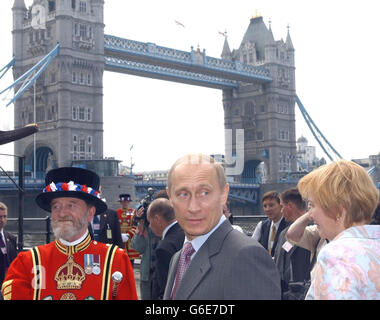 Ein Yeoman der Garde, Tom Sharp, (links) sieht, wie der russische Präsident Wladimir Putin und seine Frau Ljudmila bei ihrem Besuch im Tower of London vorbeikommen. * der russische Führer besichtigte die historische Attraktion mit seiner Frau, musste aber nicht anstehen, um die Exponate zu sehen. Stockfoto