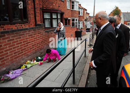 Der Labour-Abgeordnete Keith Vaz (rechts) trifft Anwohner vor dem Ort eines tödlichen Hausbrands in Wood Hill, Leicester. Stockfoto