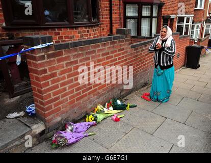 Anwohner sagt ein Gebet vor der Szene eines tödlichen Hausfeuers in Wood Hill, Leicester. Stockfoto