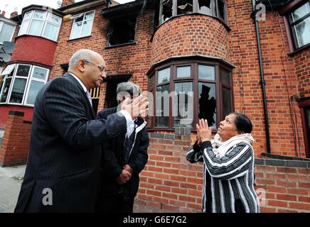 Der Labour-Abgeordnete Keith Vaz (links) trifft Anwohner vor dem Ort eines tödlichen Hausbrands in Wood Hill, Leicester. Stockfoto