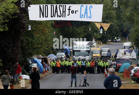 Polizeibeamte eskortieren einen Lastwagen, der zum Sondierungsbohrplatz von Cuadrilla in Balcombe, West Sussex, fährt, während die Anti-Fracking-Demonstrationen fortgesetzt werden. Stockfoto