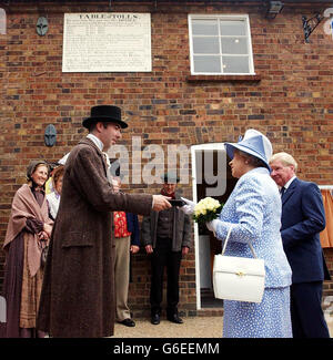 Die britische Königin Elizabeth II. Zahlt eine halbe Penny Maut an Mautshüter Guy Rowland, um sie bei einem Besuch in Ironbridge in Shropshire zu überqueren. Die Königin besuchte die Gegend, um das New Visitor's Center auf dem Gelände zu eröffnen. Stockfoto