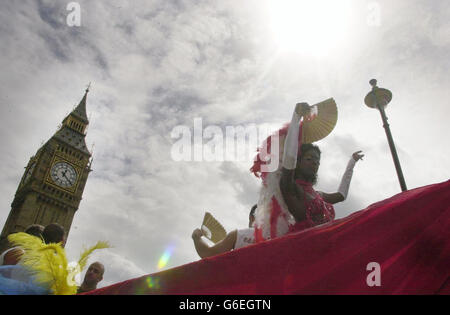 Feiernden passieren Westminster im Zentrum von London, als Teil der Gay Pride Mardi Gras 2003 Parade. Die Parade führt durch das Zentrum Londons zum Hyde Park, wo Pride in the Park stattfinden wird, wo bis in den Abend viele Acts und Künstler auf zahlreichen Bühnen auftreten. Stockfoto