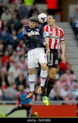 John O'shea von Sunderland, Right und Wayne Rooney von Manchester United, verließen die Challenge während des Barclays Premier League-Matches Sunderland gegen Manchester United im Stadium of Light, Sunderland Stockfoto