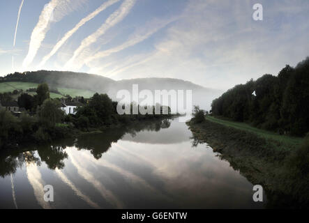 Am frühen Morgen verharren Nebel, wenn die Sonne über Brockweir im Wye Valley aufgeht. Stockfoto