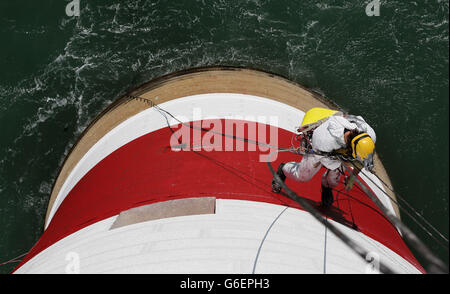 Der Spezialabseiler Hugh Waddivor wird vom Beachy Head Lighthouse in Eastbourne, Sussex, suspendiert, als nach einer erfolgreichen Spendenaktion zur Rettung der Streifen die letzten Farbanstriche auf die Struktur aufgebracht werden. Stockfoto