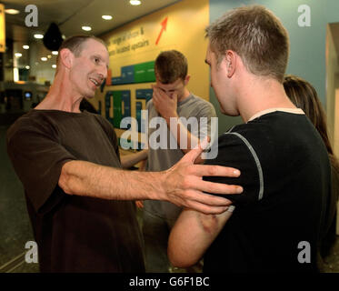 Christian Johnson, 22, (rechts) und sein Bruder Frederick, 18, werden von ihrem Vater Andy Staermose, 45, am Flughafen Gatwick aus Athen empfangen. Die Brüder - die wegen Übergreifens eines Café-Besitzers verurteilt wurden - sprachen von ihrer lebenden Hölle durch die Hände der griechischen Polizei, als sie am Flughafen Gatwick ankamen. In Gatwick sagten sie, sie hätten den Cafe-Besitzer Dimitris Karamichalos provoziert, den sie mit einer Metallstange auf den Kopf schlagen. Die beiden wurden zu einem Jahr Gefängnis verurteilt oder zahlen eine Geldstrafe für den Übergriff auf Herrn Karamichalos. Beide legten Berufung ein und durften Griechenland verlassen. Stockfoto