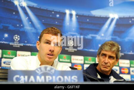 Edin Dzeko von Manchester City spricht während einer Pressekonferenz im Etihad Stadium, Manchester, mit dem Manchester City Manager Manuel Pellegrini (rechts). Stockfoto