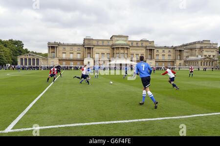 Polytechnic FC (in blau), während ihres Spiels mit dem Civil Service FC im Garten des Buckingham Palace im Zentrum von London. Stockfoto