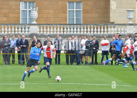 Polytechnic FC (in blau), während ihres Spiels mit dem Civil Service FC im Garten des Buckingham Palace im Zentrum von London. Stockfoto