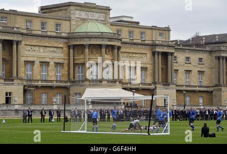 Polytechnic FC (in blau), während ihres Spiels mit dem Civil Service FC im Garten des Buckingham Palace im Zentrum von London. Stockfoto
