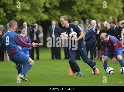 Der Duke of Cambridge trainiert mit Mitgliedern des Royal Household während der zweiten Hälfte eines Spiels zwischen dem Polytechnic FC und dem Civil Service FC, auf dem Gelände des Buckingham Palace's Garden, im Zentrum von London. Stockfoto