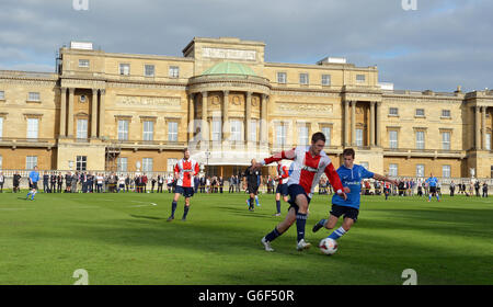 Polytechnic FC (in blau), während ihres Spiels mit dem Civil Service FC im Garten des Buckingham Palace im Zentrum von London. Stockfoto