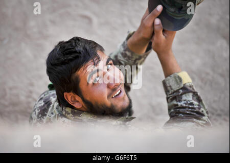 Ein Soldat der afghanischen Nationalarmee (ANA) sitzt während einer Pause zwischen dem Training im ANA Camp Shorabak, Provinz Helmand, Afghanistan, im Schatten. Stockfoto