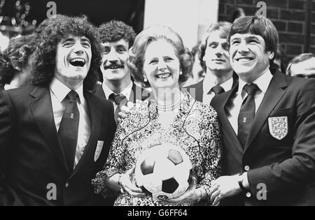 Die Premierministerin Margaret Thatcher teilt einen Witz mit den englischen Fußballern Kevin Keegan (links) und Emlyn Hughes und anderen Mitgliedern der internationalen Mannschaft vor der Downing Street 10, als sie nach der Teilnahme an einem Empfang von Frau Thatcher abreisten. Stockfoto