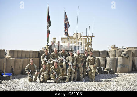 Soldaten einer mechanisierten Brigade posieren für ein letztes Gruppenfoto vor einem Husky-Fahrzeug, bevor sie die letzte verbliebene britische Patrouillenbasis, PB2, im Nahr-e Saraj Bezirk, Provinz Helmand, Afghanistan, verlassen. Während sie sich schließt und die Truppen aus dem ehemaligen strategischen Standort in der Grünen Zone herausziehen, der im Laufe der Jahre schwere Kämpfe erlebt hat und nun vollständig von afghanischen Truppen im Rahmen des Rückzugs übernommen wird, um 2014 den vollständigen Abzug der britischen Streitkräfte zu erreichen. Stockfoto