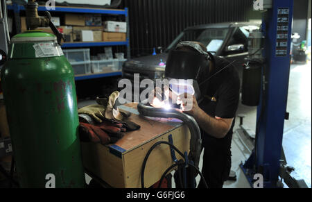 Ein Mechaniker arbeitet an einer Auspuffanlage mit Gas Wolfram Lichtbogenschweißen Stockfoto