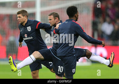 Der englische Steven Gerrard (links) wärmt sich mit seinen Teamkollegen Wayne Rooney auf Und Daniel Sturridge (rechts) vor dem Spiel Stockfoto