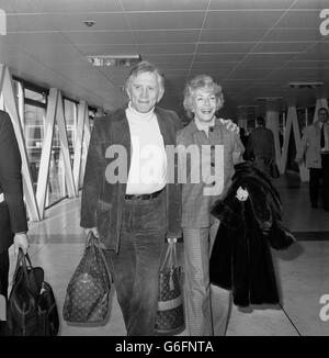 Der Hollywood-Schauspieler Kirk Douglas, 60, mit seiner Frau Anne am Londoner Flughafen Heathrow, wo sie nach New York flogen. Stockfoto