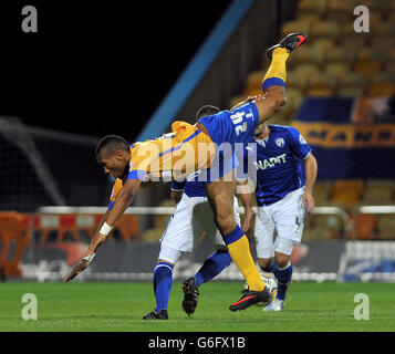 Fußball - Johnstones Paint Trophy - Mansfield Town / Chesterfield - One Call Stadium. Calvin Andrew von Mansfield Town stürzt ein, nachdem er von Sam Morsy (hinten) und Sam Hird (rechts) in Angriff genommen wurde. Stockfoto